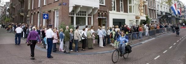 Een lange rij mensen staat donderdag buiten Theater Carré in Amsterdam te wachten. 